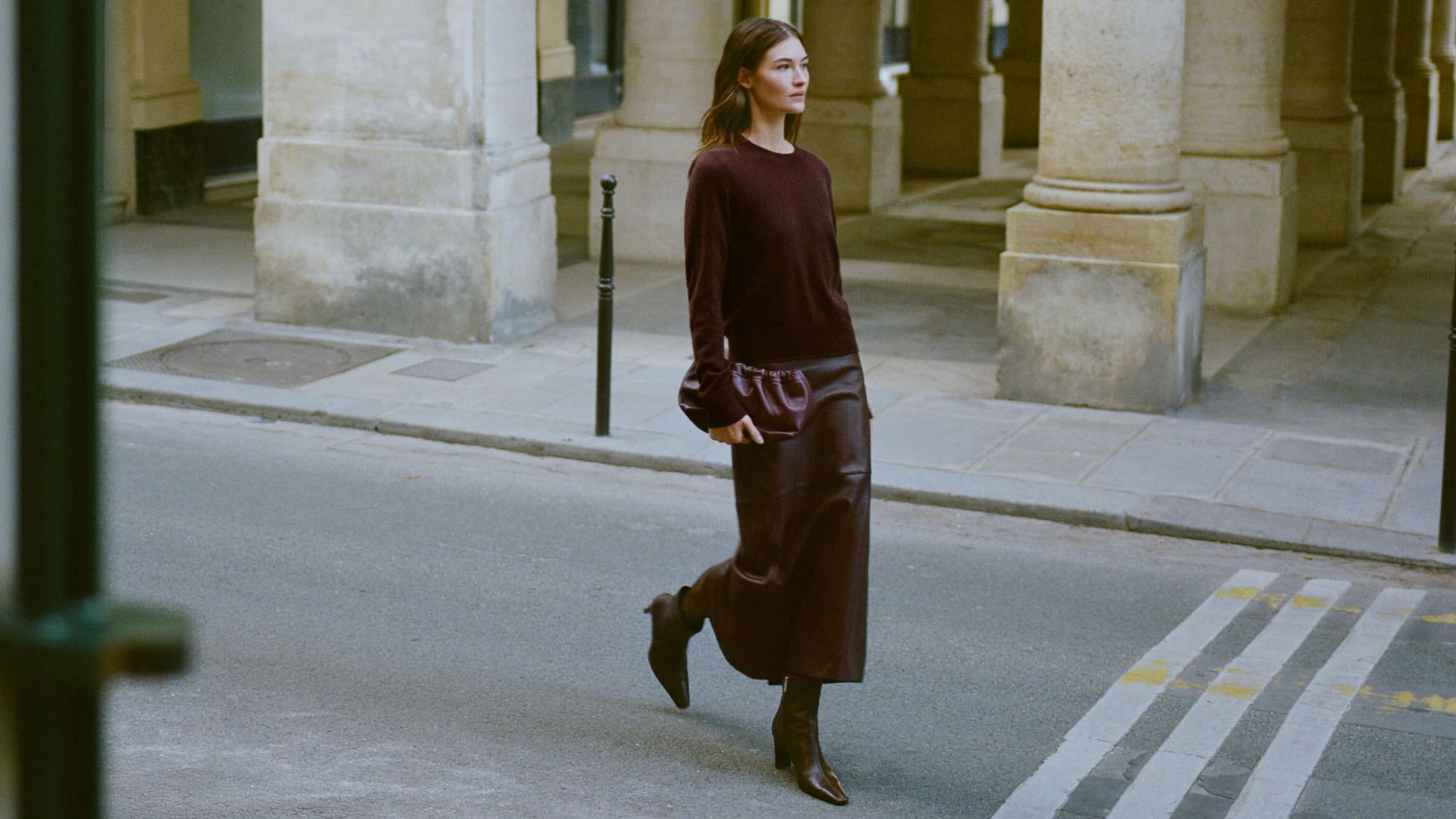 a model wearing a brown jumper skirt and boots from reformation