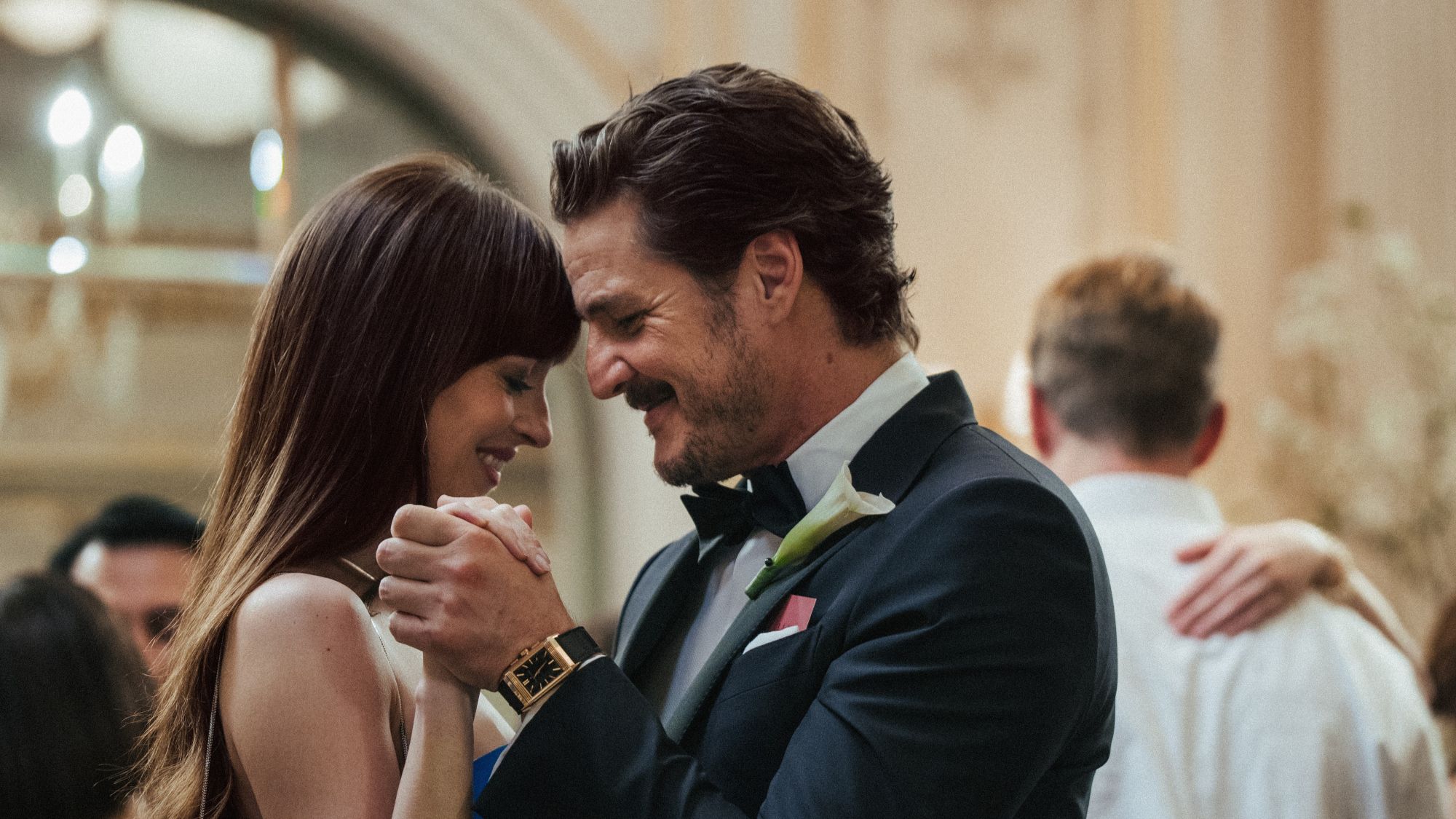 Dakota Johnson and Pedro Pascal smiling and dancing in Materialists