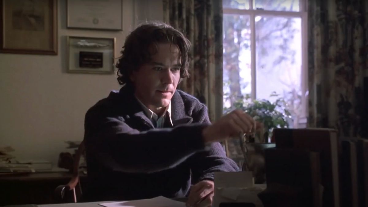 Timothy Hutton reaches for a pencil at his desk in The Dark Half.