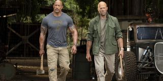 Hobbs & Shaw walking out of the Hobbs garage, carrying weapons