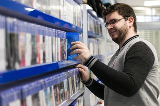 Profile of a handsome young guy browsing the gaming section at a local store
