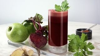 Glass of beetroot juice with coriander, apples, and ginger