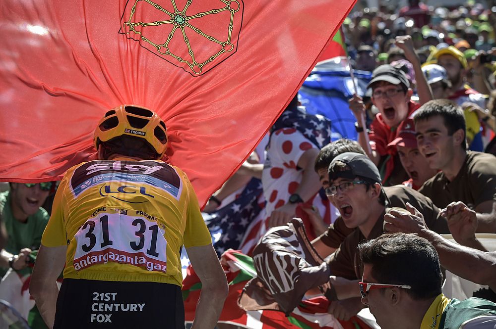 Team Sky's Chris Froome breaks through fans on the climb to Team Sky's Chris Froome