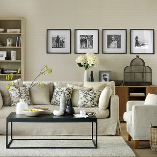 living room with cream wall and line up photo frame