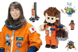 Photo showing JAXA astronaut Naoko Yamazaki in an orange spacesuit next to some of the Nanoblock space series models she advised on.