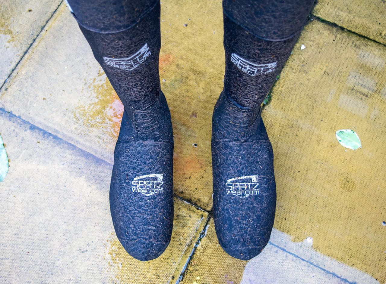 A pair of Spatz overshoes covered in mud and grit after a wet ride
