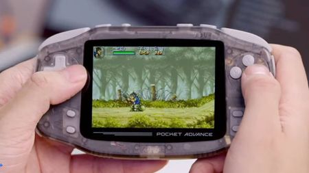 Hands holding KONKR Pocket Advance Onxy Ice with Metal Slug playing on screen.