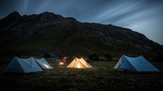 Four tents pitched at night in the Lake District, UK