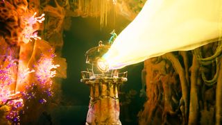 A screenshot of Keeper from Double Fine Productions featuring a lighthouse shining a bright beam of light inside of a cave with glowing coral.