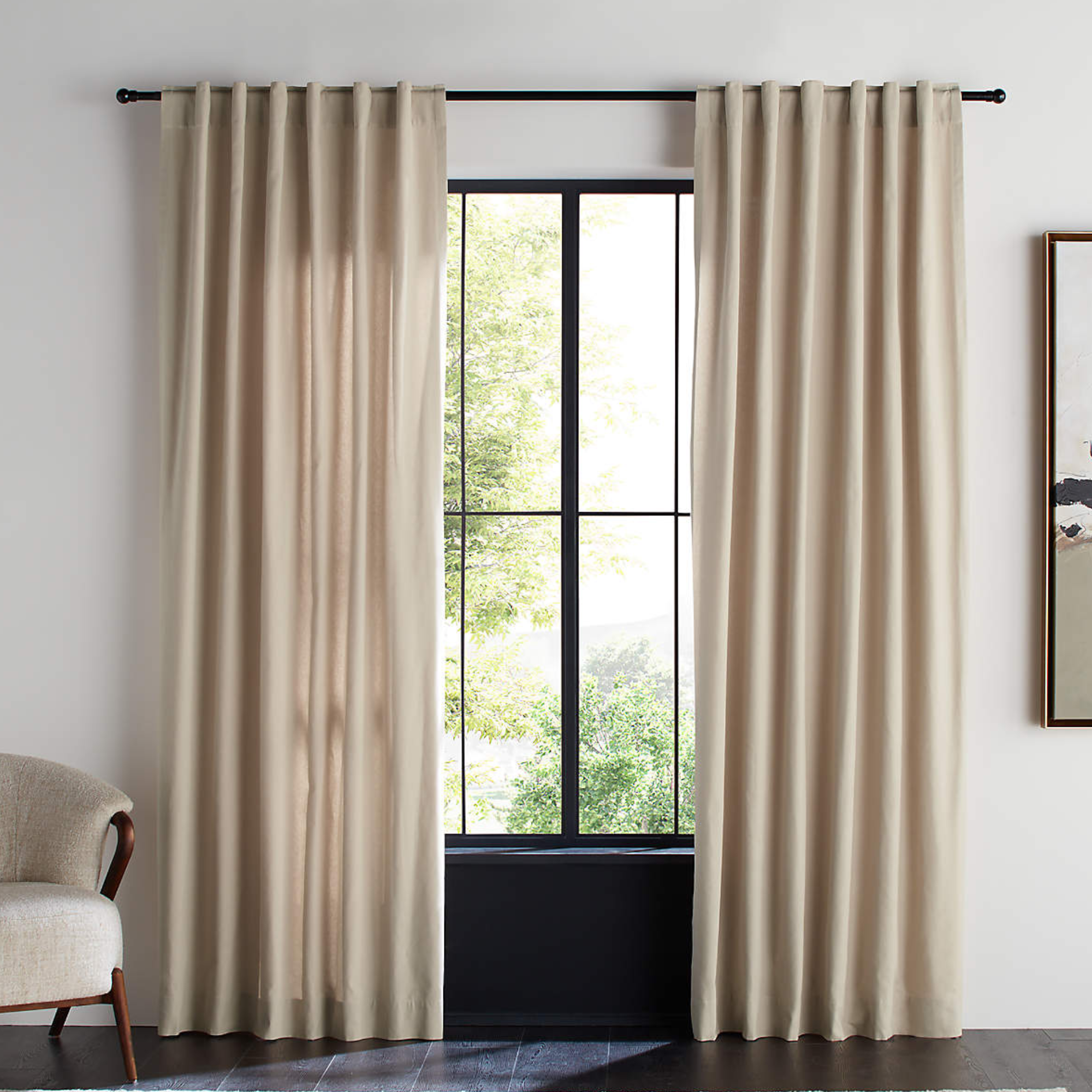 two tan curtains hanging over a large window
