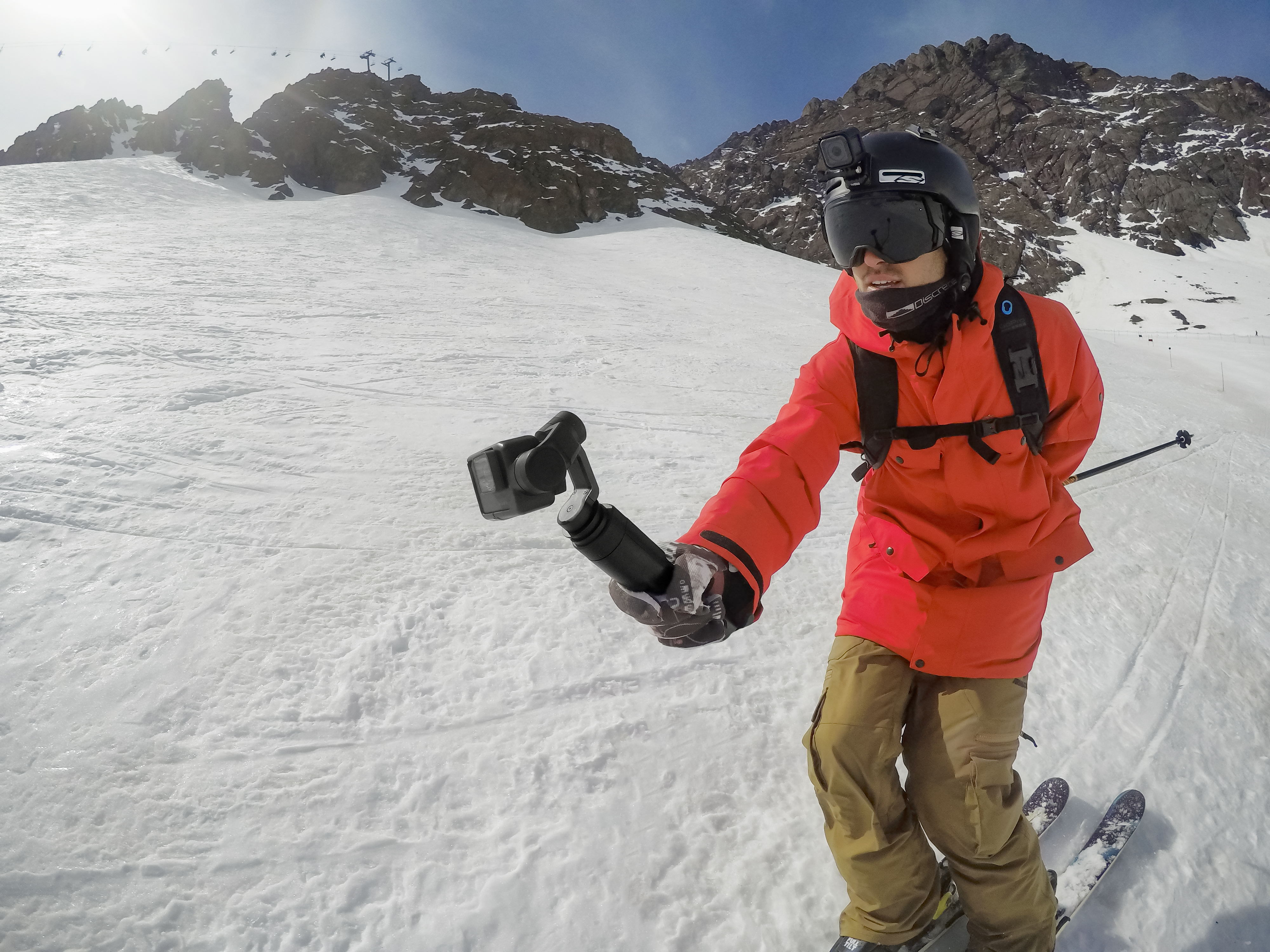 A skier films himself skiing down a hill