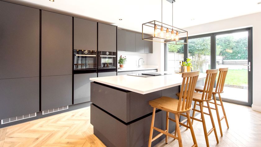 Contemporary kitchen with dark grey wall to floor units and island with white quartz worktop
