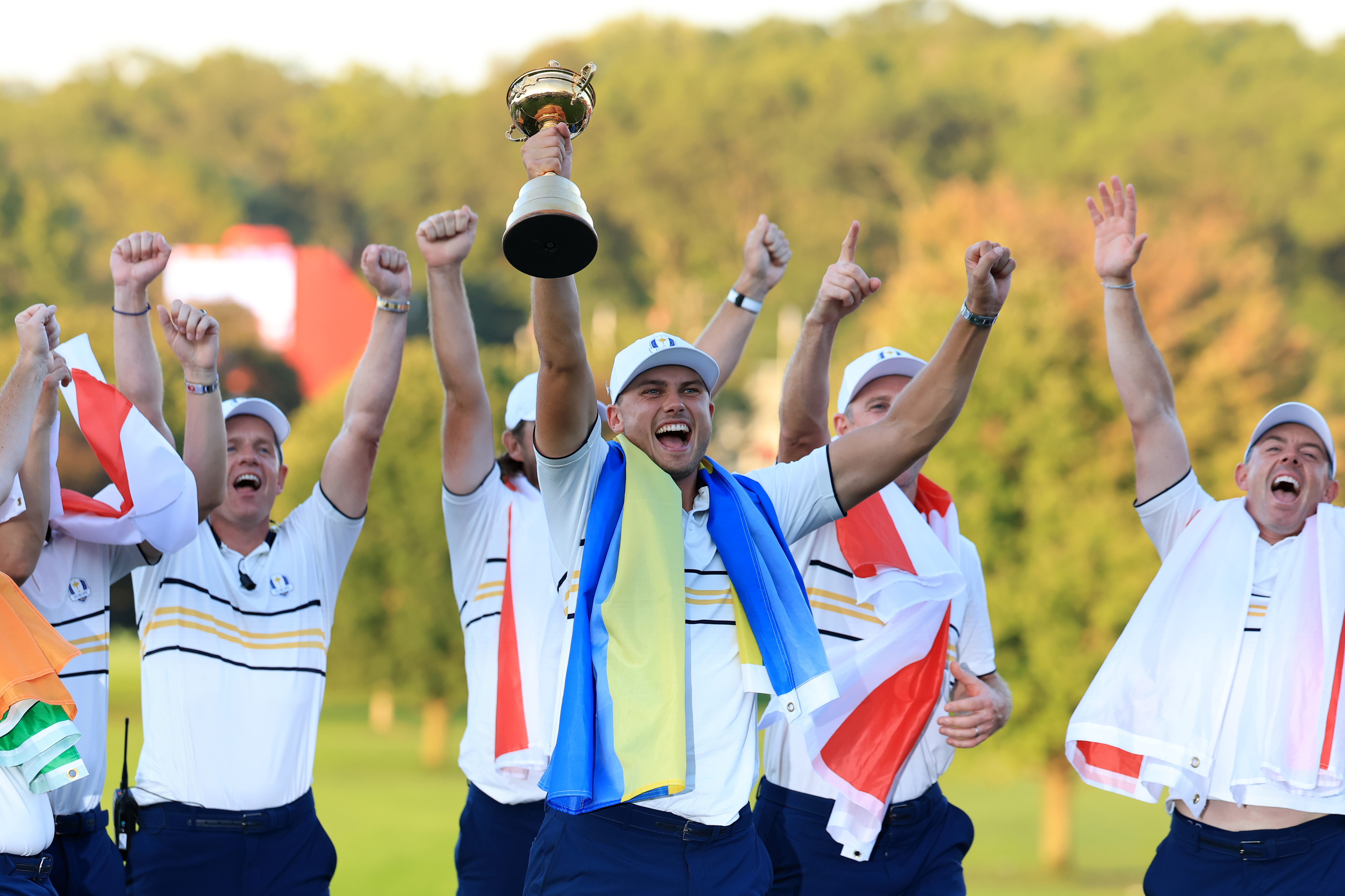 Ludvig Aberg lifts the Ryder Cup aloft with a Swedish flag draped around his shoulders