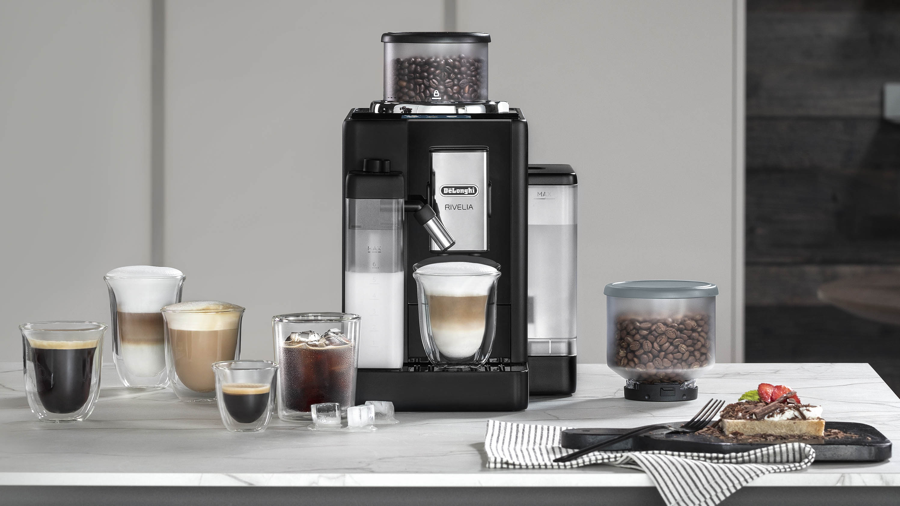 De’Longhi Rivelia espresso machine on countertop with coffee drinks