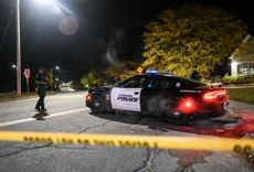 Police officers close the road as they patrol around the street during inspection after a gunman's multiple shootings in Maine