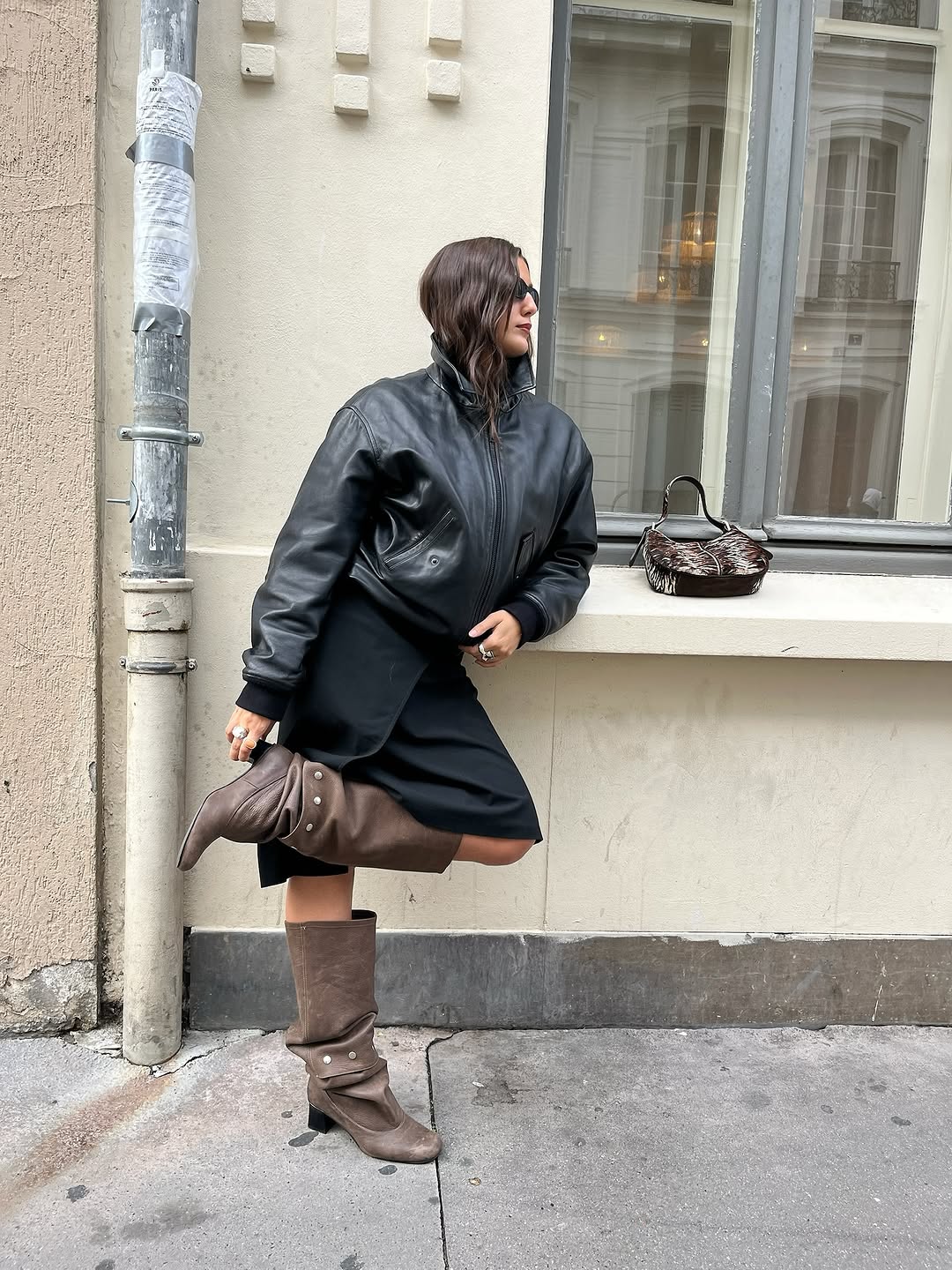 Woman wearing fall boots with skirt outfit 2025.