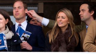 Prince William has his ear pulled by a friend as he watches the racing on Day 4 of The Cheltenham Festival at Cheltenham Racecourse on March 15, 2013