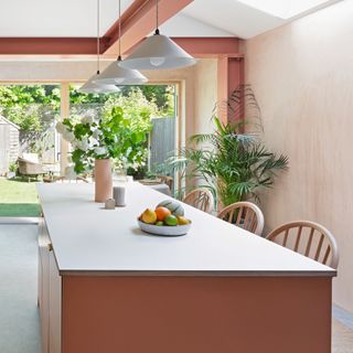 peach and terracotta kitchen with island unit underneath ceiling lights