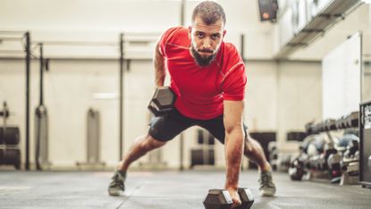 Man doing renegade row exercise with dumbbells