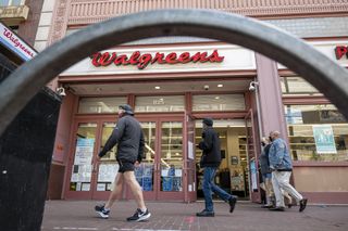Pedestrians wearing protective masks walk past a Walgreens store in San Francisco, California, U.S., on Tuesday, April 13, 2021.