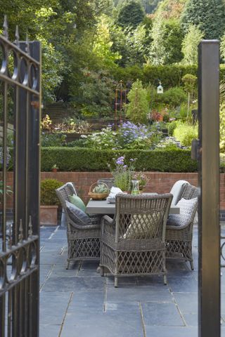 Garden table with wicker chairs and cushions