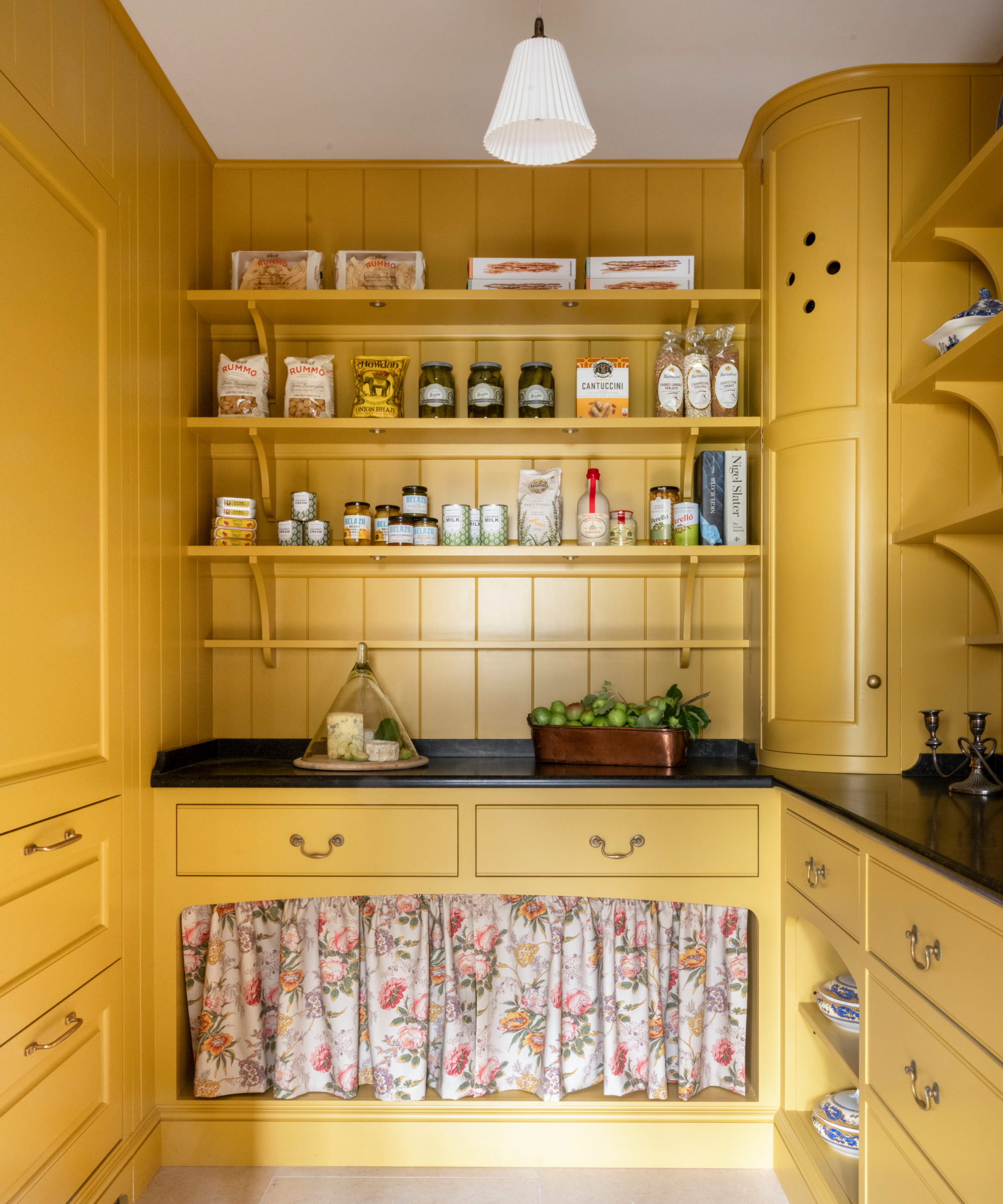 walk in pantry with yellow cabinetry, shelving and wall panelling