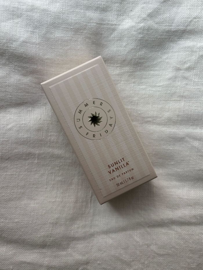 The Summer Fridays Sunlit Vanilla perfume on a white linen background