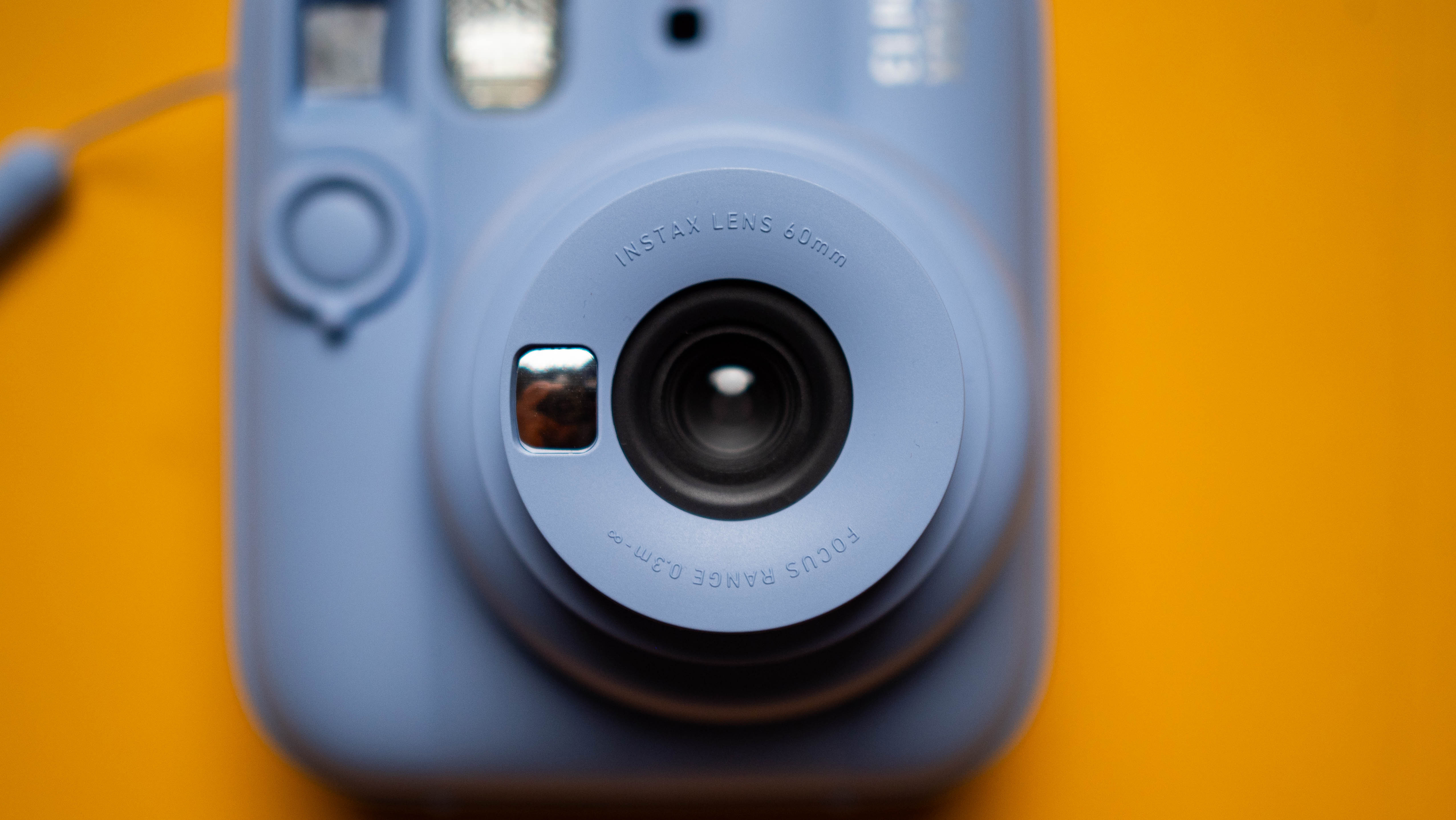 Fujifilm Instax Mini 13 instant camera against a yellow colored sheet