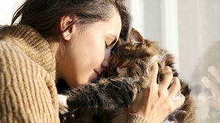 Woman cuddling fluffy cat