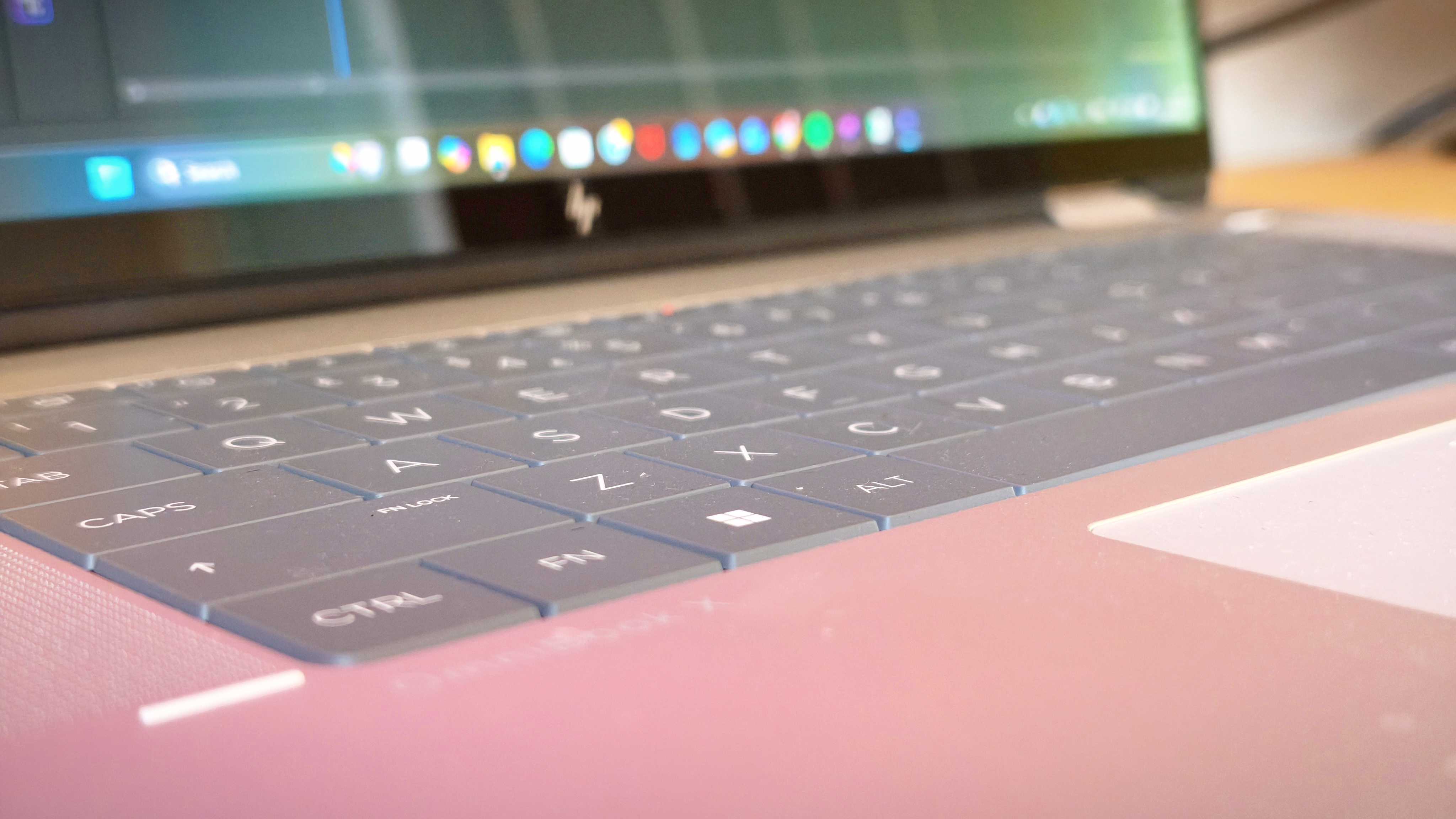 A silver HP Omnibook X Flip 16 2-in-1 laptop on a wooden desk