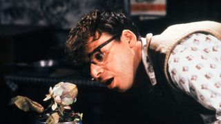 Rick Moranis looks at a plant in Little Shop of Horrors
