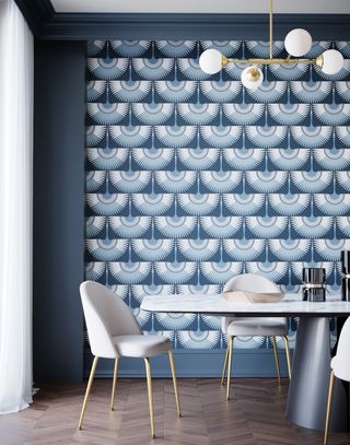 A dining room with a white dining set and blue art deco print wallpaper on the walls