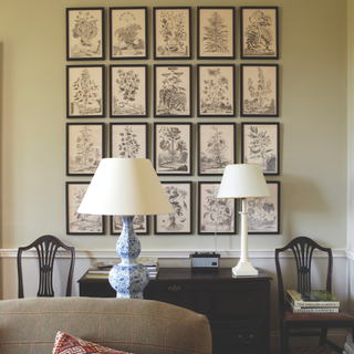 A cream painted living room with gallery wall above sideboard