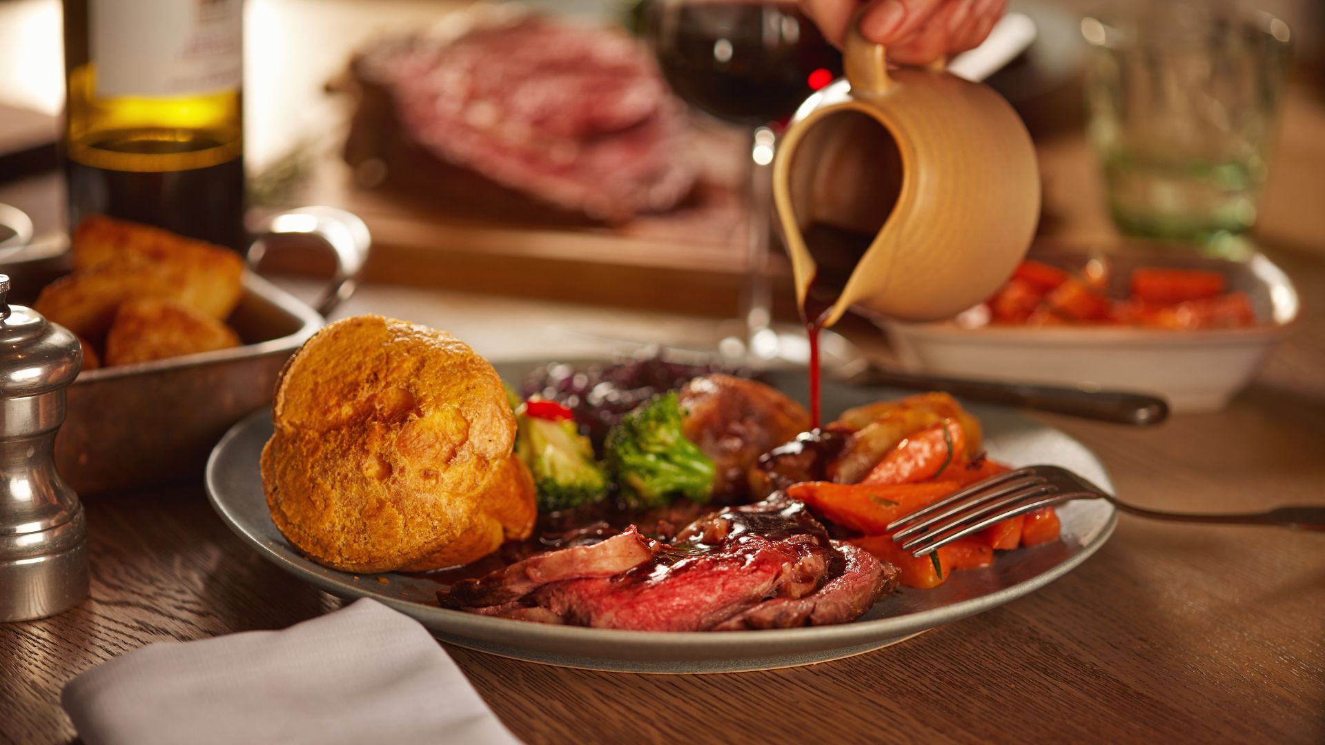 an image of a sunday roast on a plate with gravy being poured over it