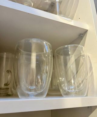 Two shiny glasses on white shelf kitchen cupboard