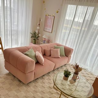Pink velour 3-seater in modern living room with cream tufted area rug