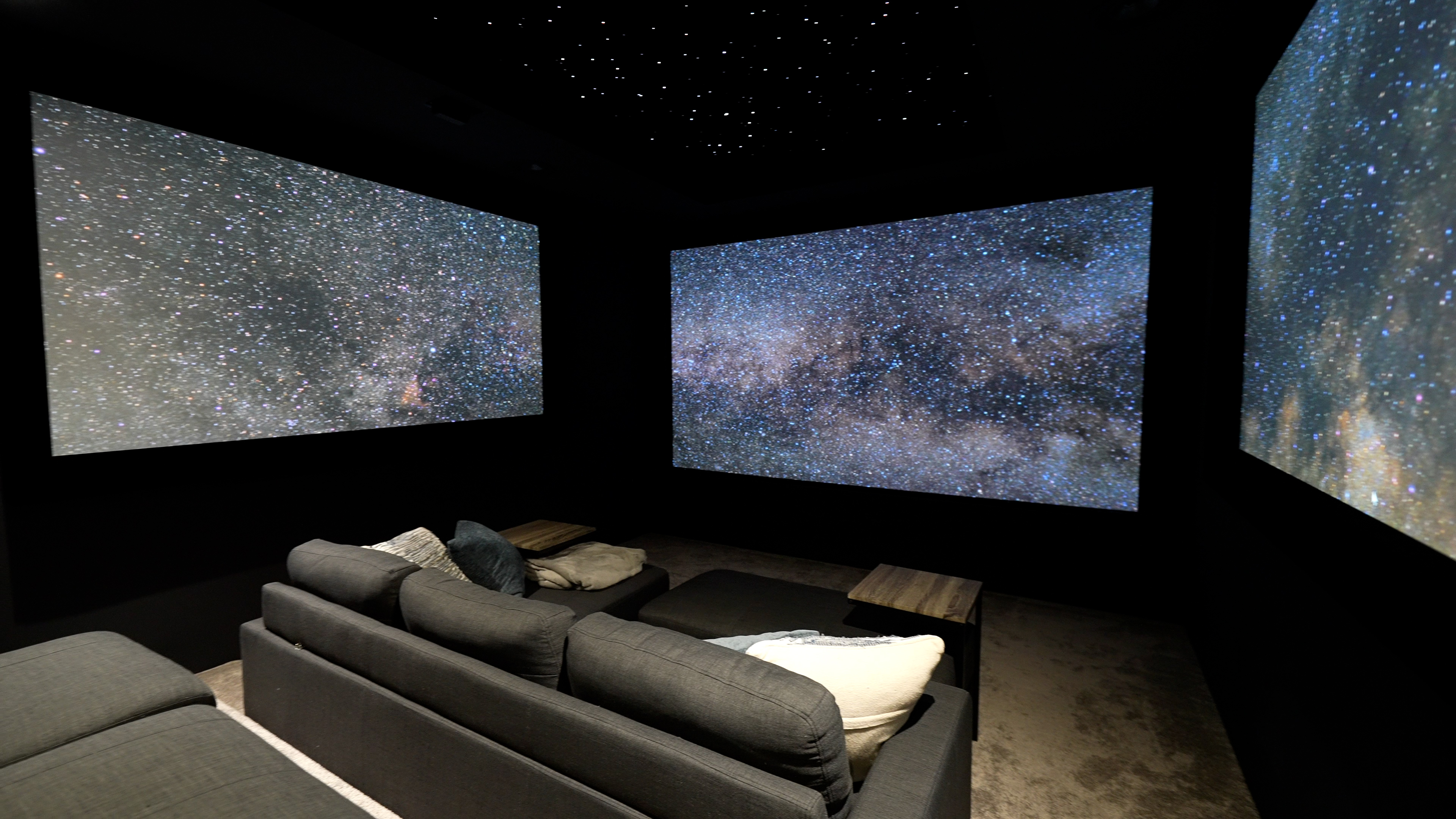 images of The Ultimate Home Theater Gaming Setup theater showing three projection screens, sofas and gaming peripherals