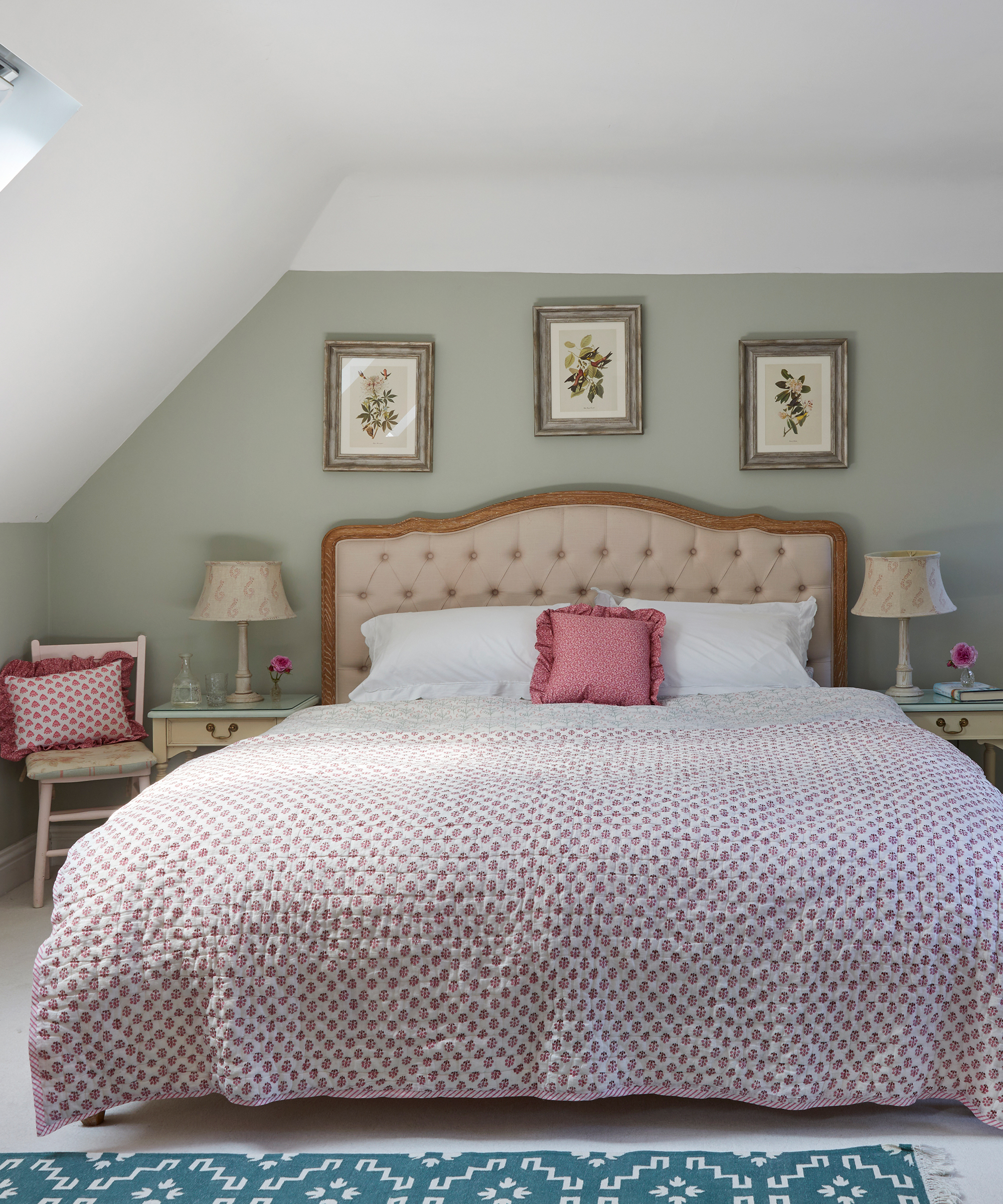 loft bedroom with green walls, upholstered headboard and patterned bedspread