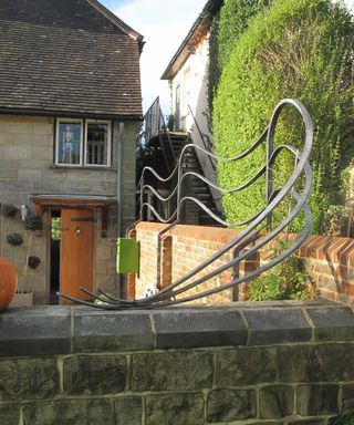 bespoke metal wall railings on top of a stone garden wall