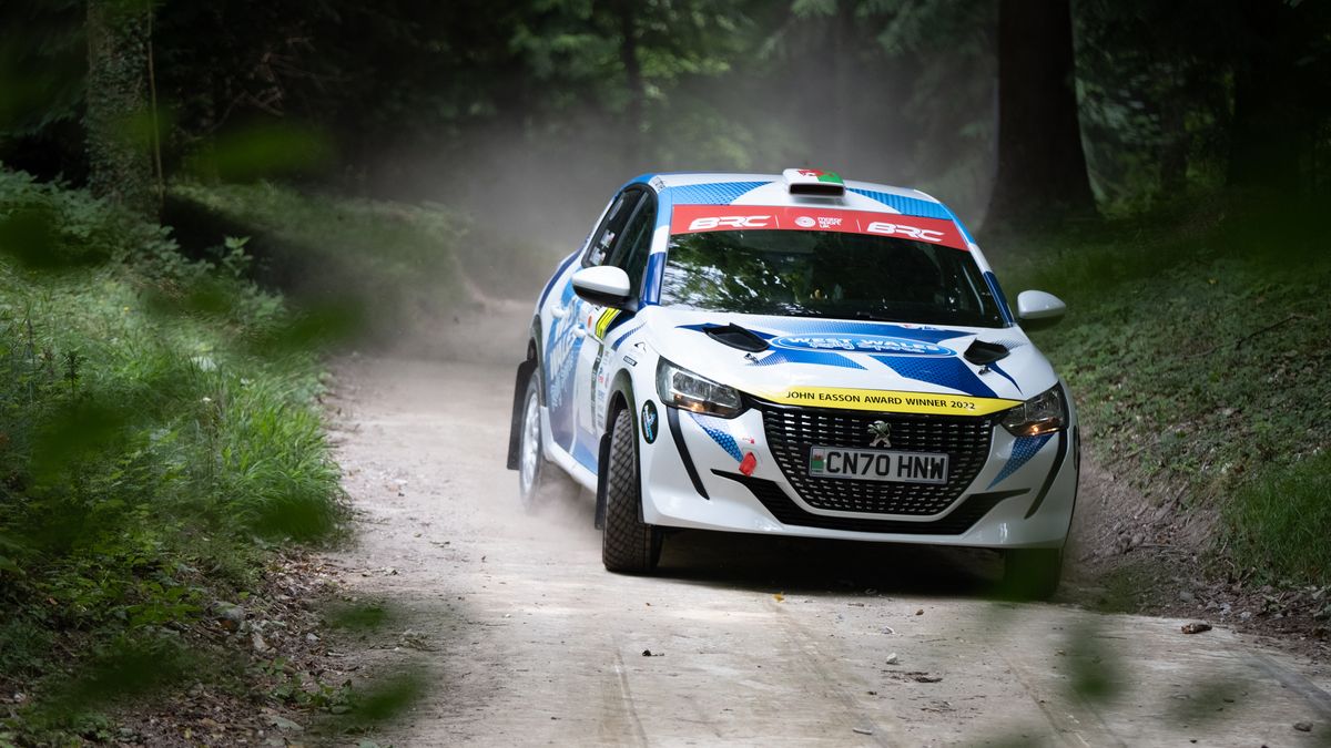 A rally car turning the corner of a race track at Goodwood