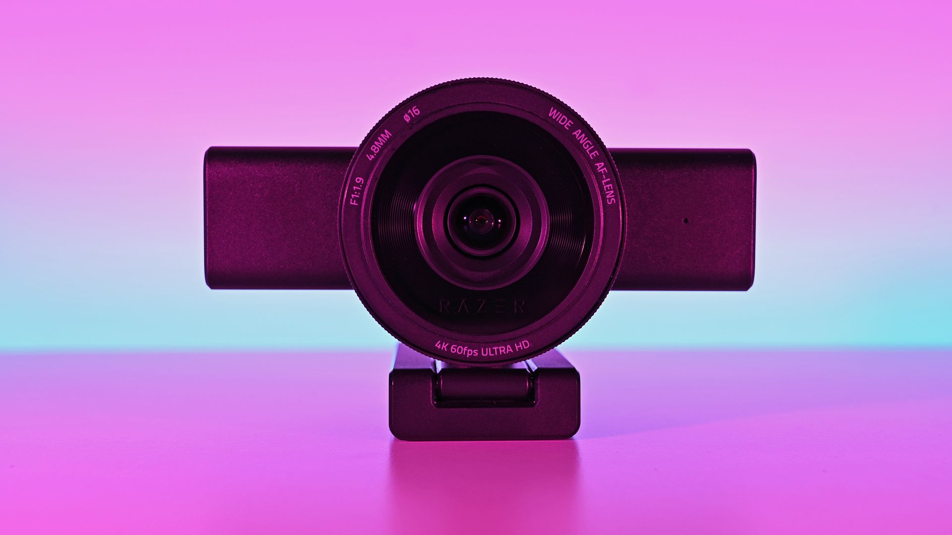 Front view of the Razer Kiyo V2 Pro webcam on its monitor stand against a pink-and-blue gradient backdrop.