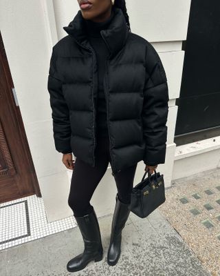 Easy winter outfits: @nlmarilyn wears a puffer jacket with leggings and knee-high boots