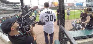 DP Joe Gabriel covers NBC news anchor Lester Holt, shown as he’s about to throw out the first pitch at a Chicago White Sox game during a cross-country trip with the Nightly News.