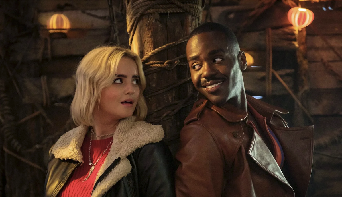 New Doctor Ncuti Gatwa and his new companion Ruby (Millie Gibson) pose back to back for the Doctor Who Holiday Special — The Church on Ruby Road