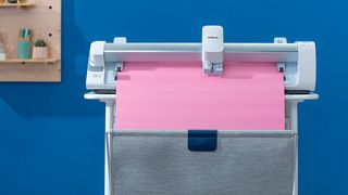 Cricut Black Friday live blog; a large white cutting machine with pink paper