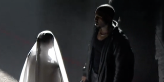 Kim Kardashian and Kanye West stand face to face at their on stage "wedding"
