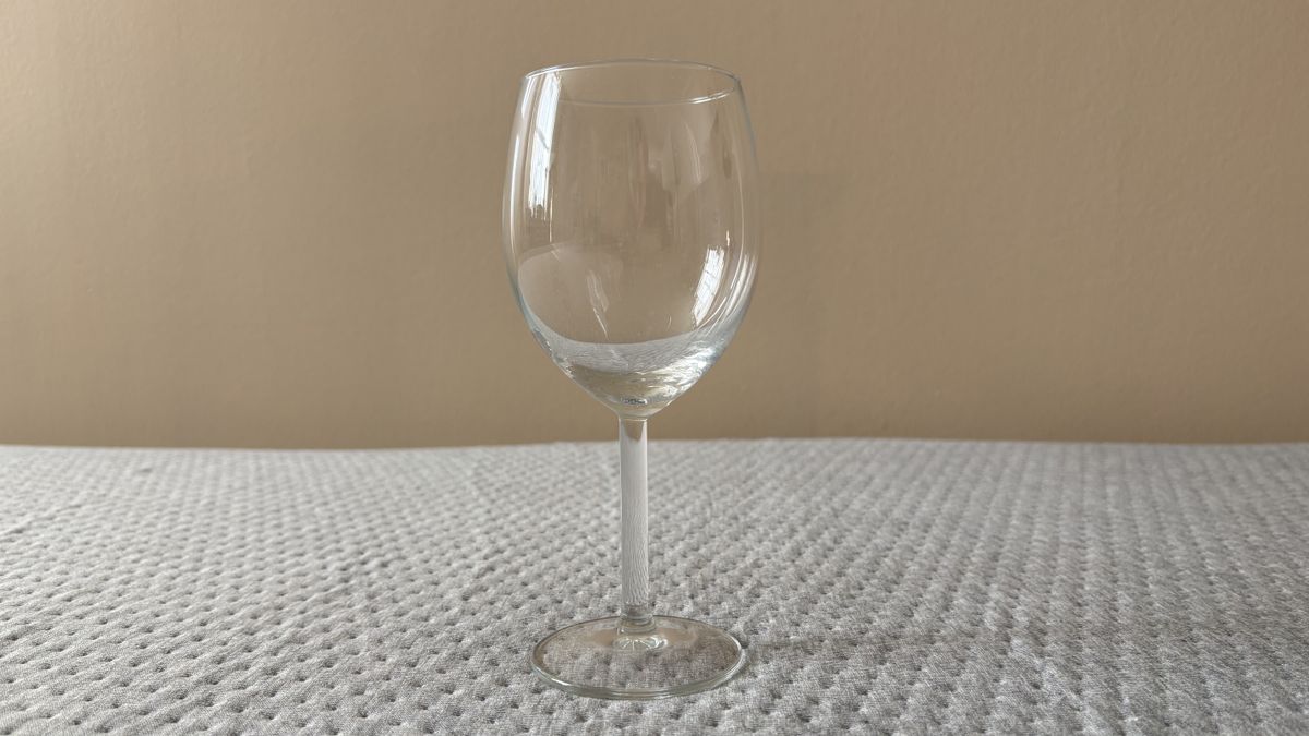 An empty wine glass on top of the Casper One Mattress during a motion isolation test