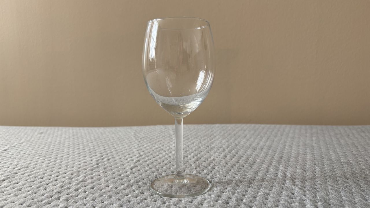 An empty wine glass on top of the Casper One Mattress during a motion isolation test