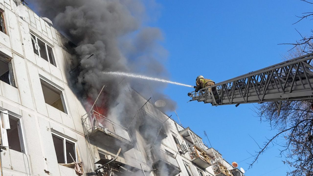 Ukrainian firefighters respond to the Russian shelling on an apartment bloc in Kharkiv