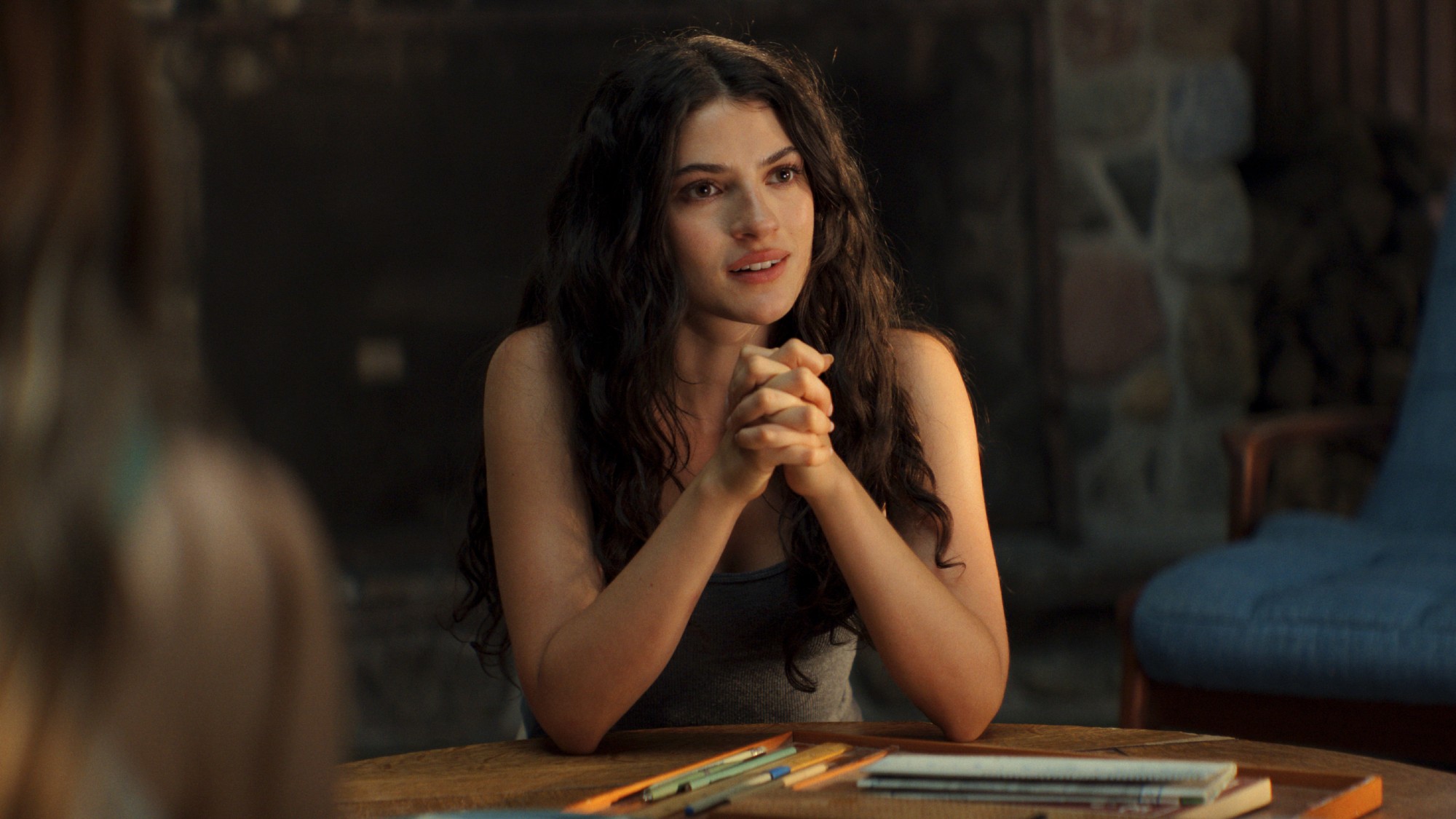 Annis with her hands clasped against a table. 